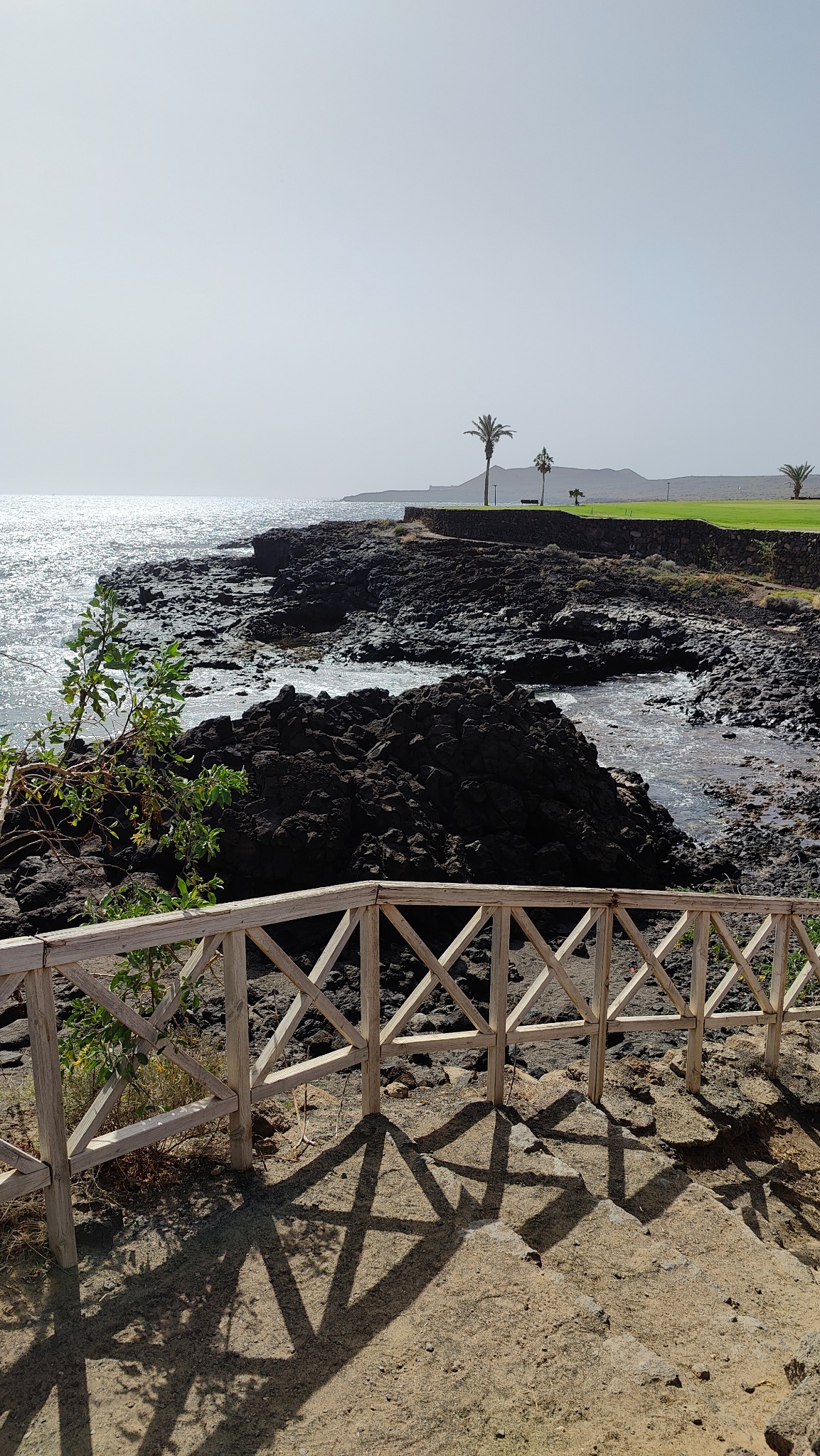 Rocky coastline and walking path near Golf del Sur